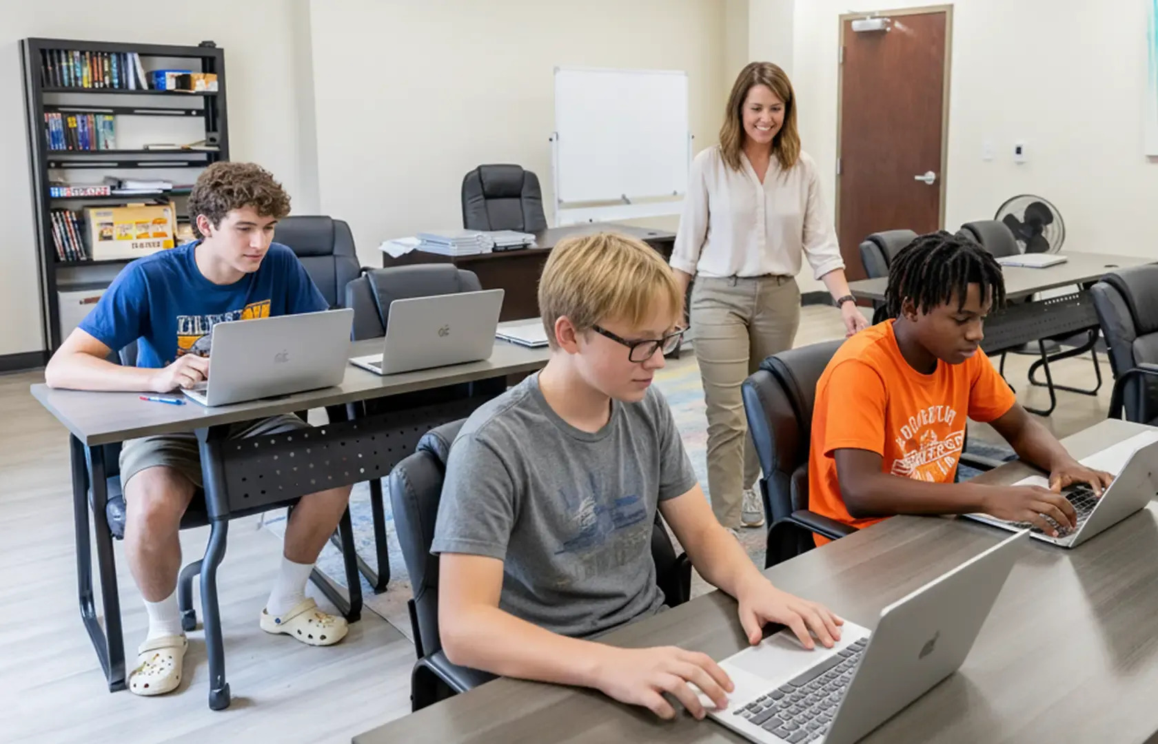 Adolescent boys using laptops in a supervised classroom setting.