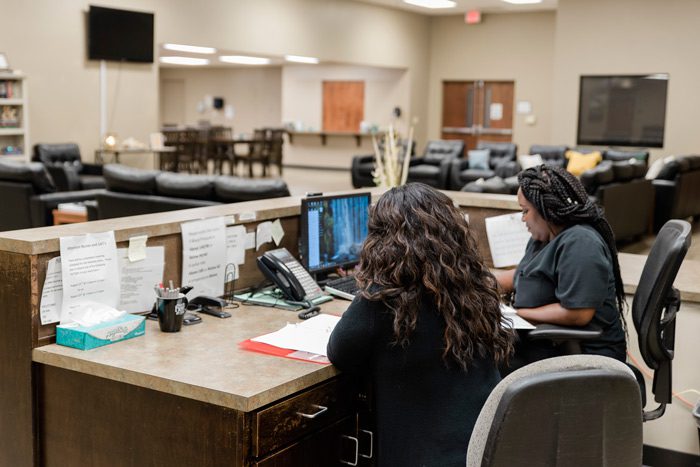 Two staff members working at front desk in common area
