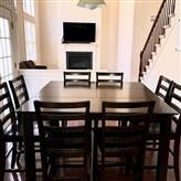 Dining area with dark wooden table and chairs near fireplace.