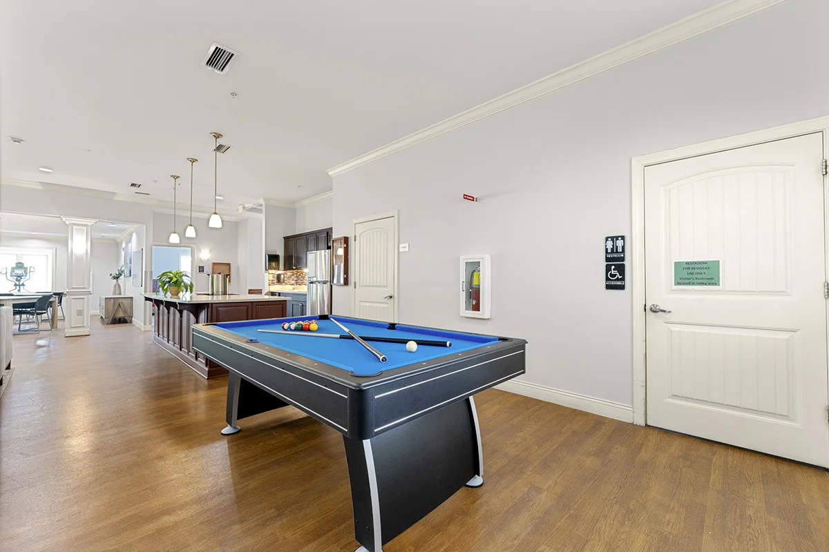 Recreation area featuring a pool table adjacent to the community kitchen and common space