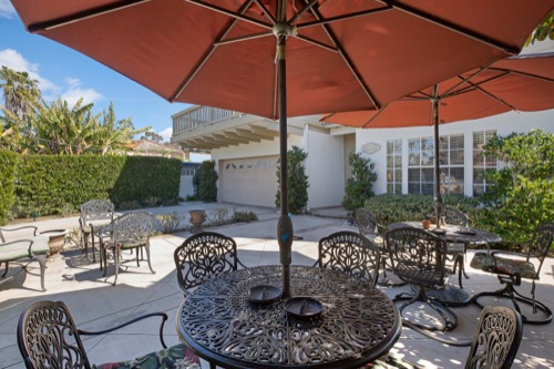 Outdoor tables with umbrellas and chairs in courtyard
