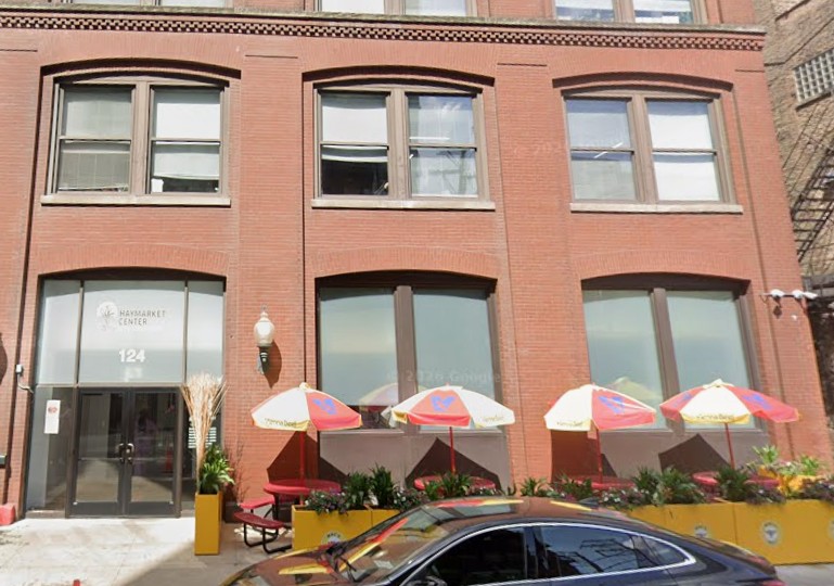 Exterior entrance of McDermott Center at Haymarket Center with brick façade, main entrance, and outdoor seating area