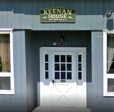 Keenan House entrance with white double door and green sign