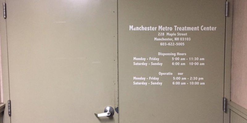 A beige door with the name and operational hours of a treatment center displayed, providing clear information for visitors and clients.