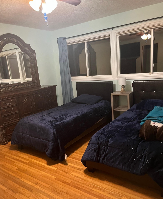 Two twin beds with dark bedding in a cozy shared bedroom