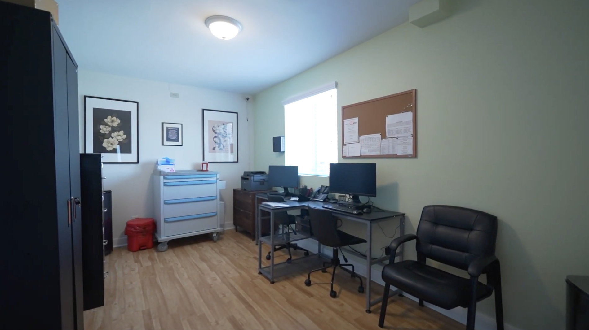 Office with desks, computers, medical cart, and seating