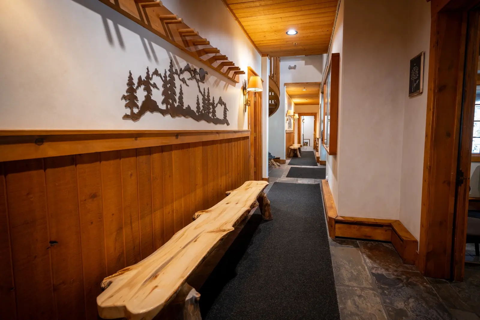 Rustic hallway with wood paneling and tree decor on the wall