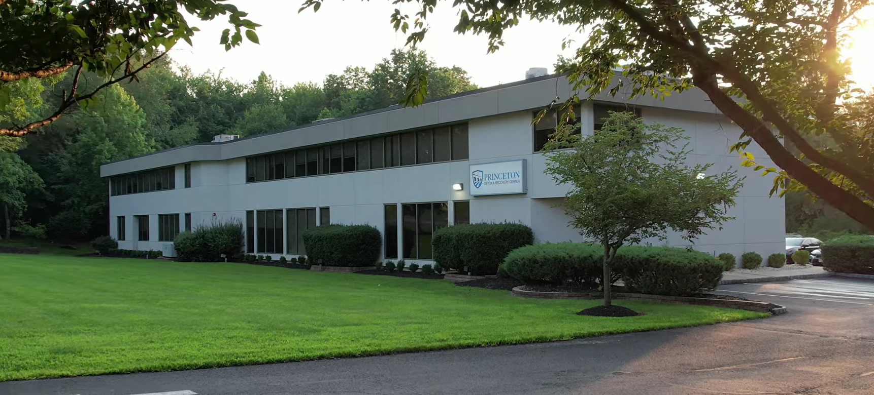Exterior of treatment center surrounded by trees and lawn