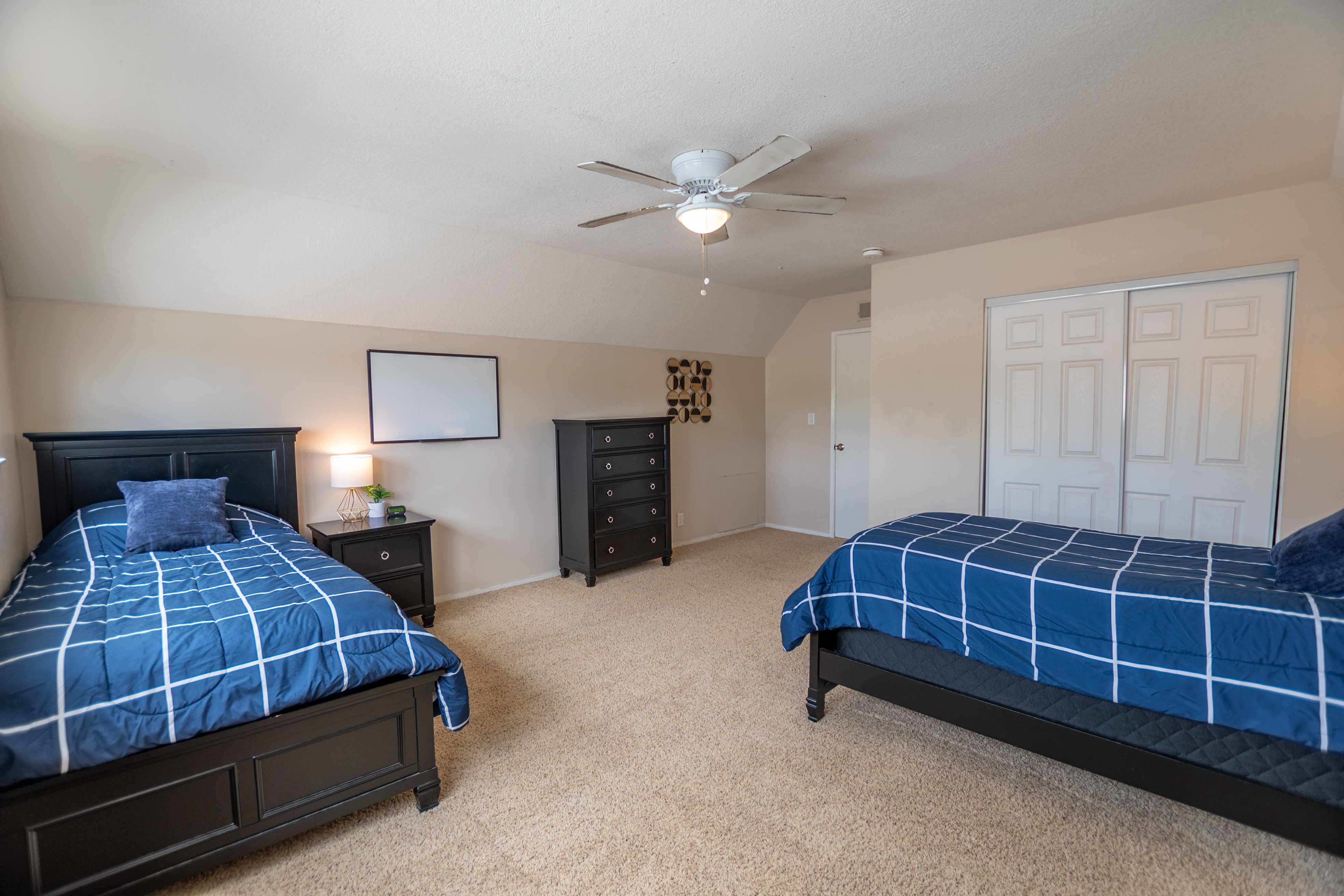 Two beds and dressers in carpeted bedroom