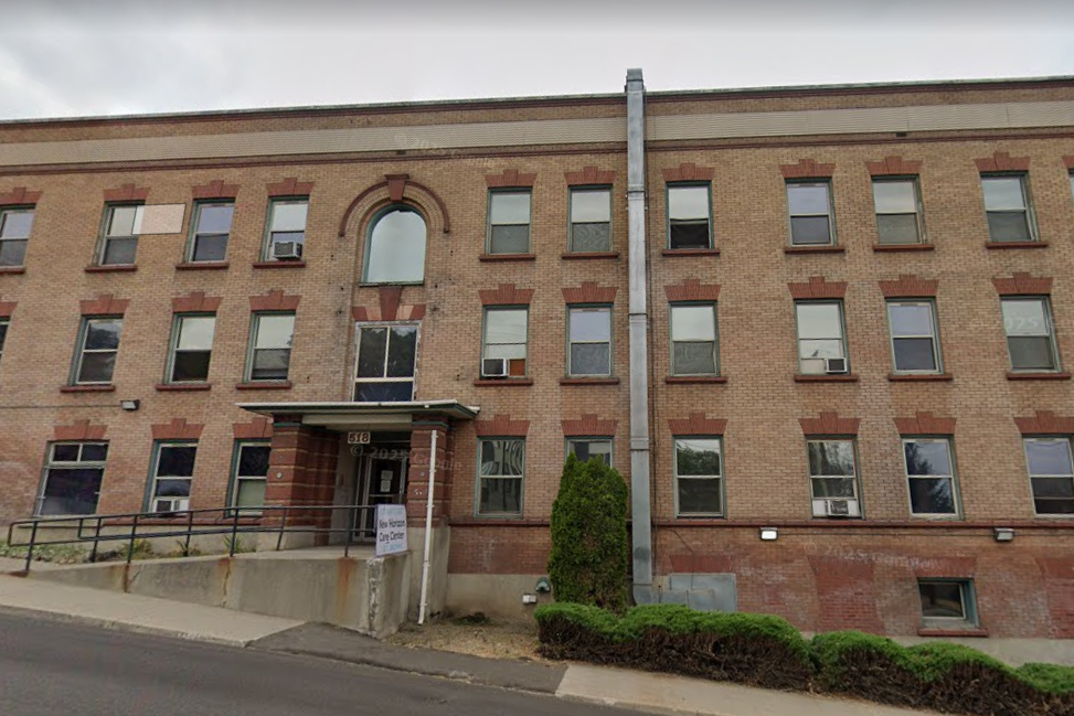 Multi-story brick rehab facility with front entry and sign