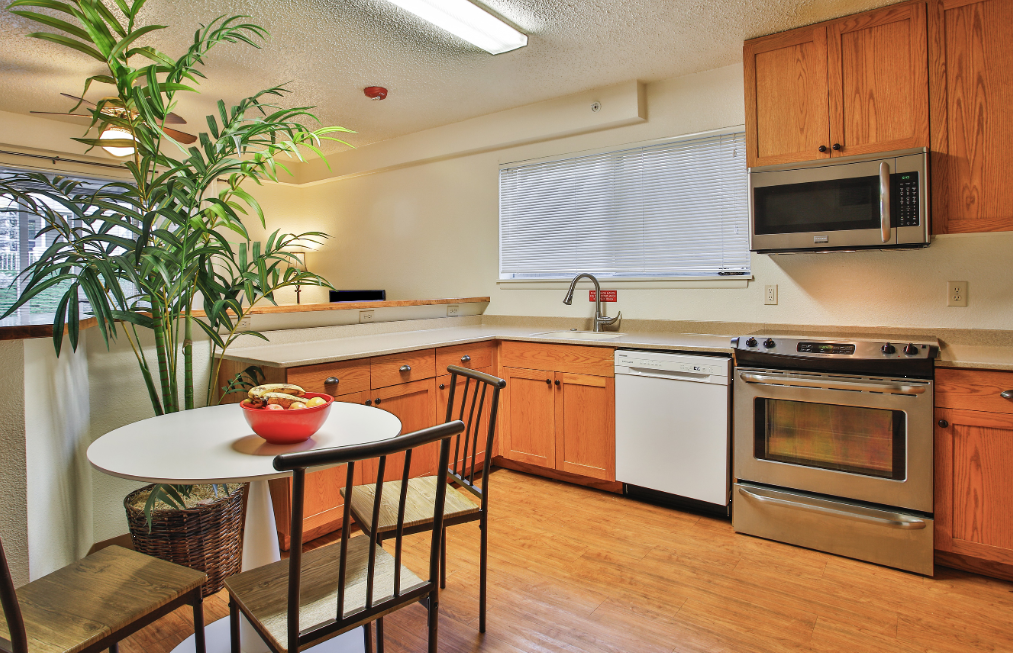 Small dining table and kitchen area with wood cabinets