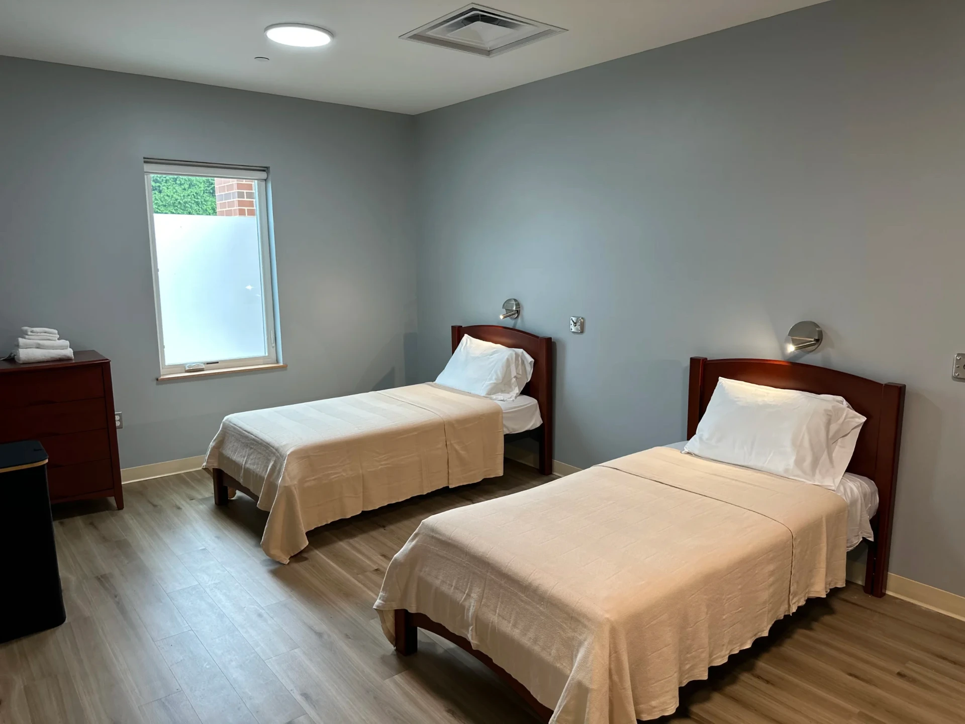 Shared bedroom with two twin beds and natural light.