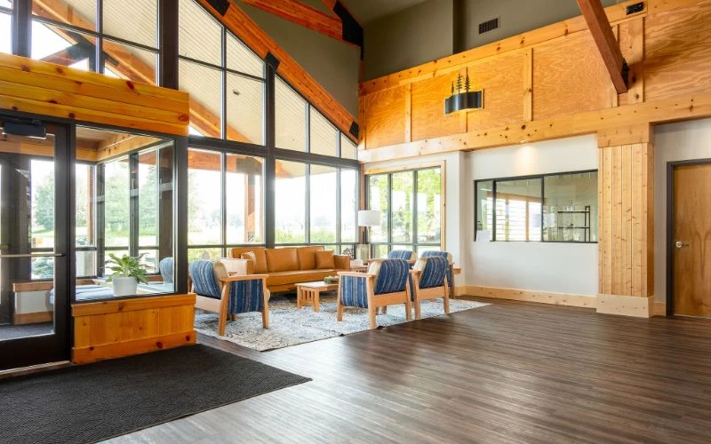 Seating area by tall windows and wood walls