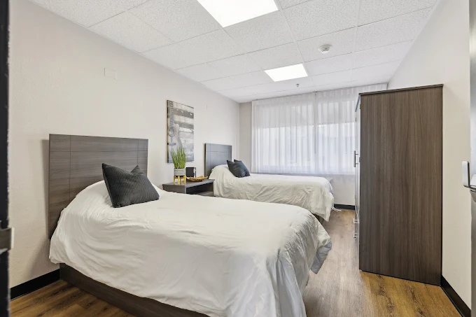 Bright shared bedroom with twin beds and wood flooring