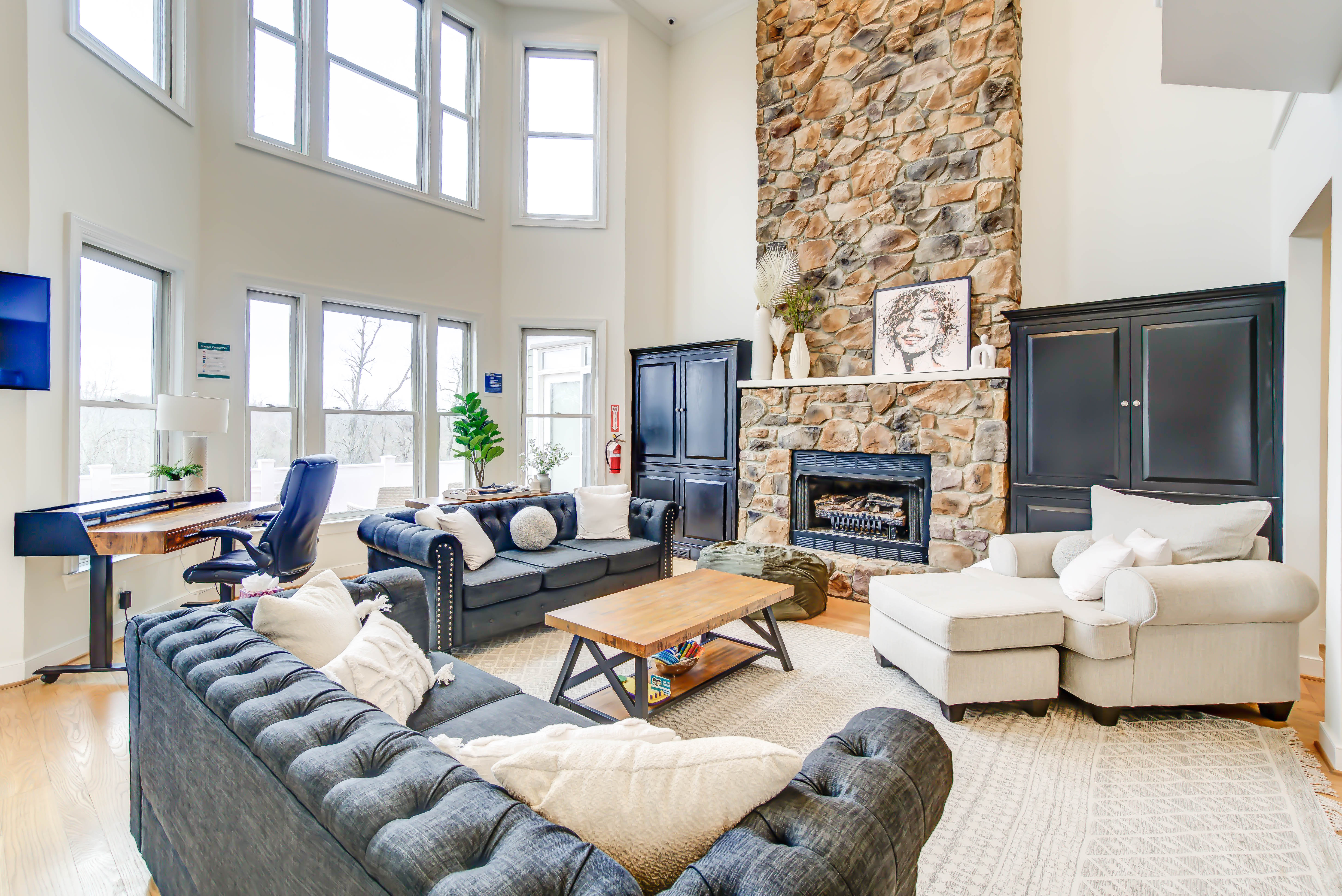 Cozy great room with stone fireplace and tall windows