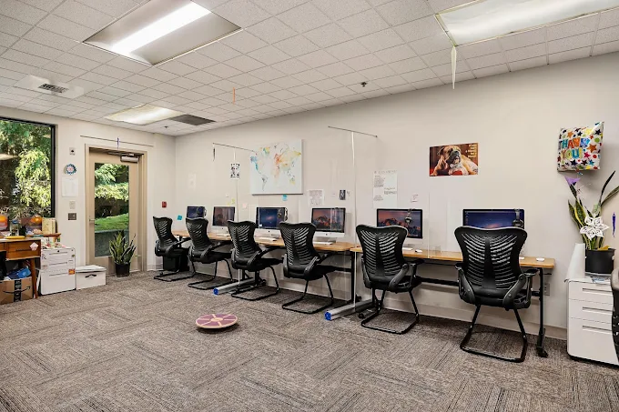 Computer lab with rows of monitors and study desks