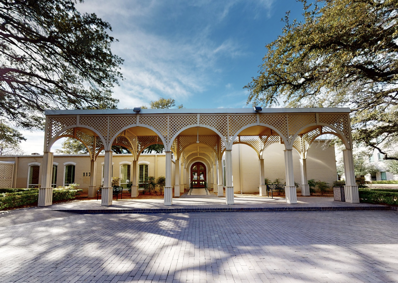 A grand arched entrance with a paved driveway.