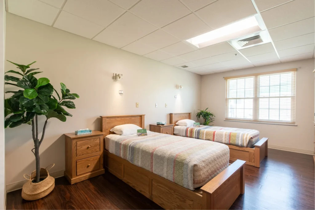 Twin-bed patient room with natural light and wood floors