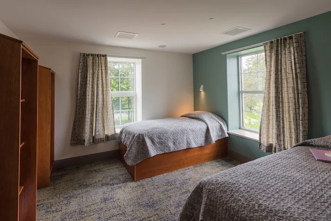 Shared bedroom with two beds and large windows