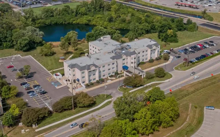 Aerial view of the facility, parking areas, and nearby pond