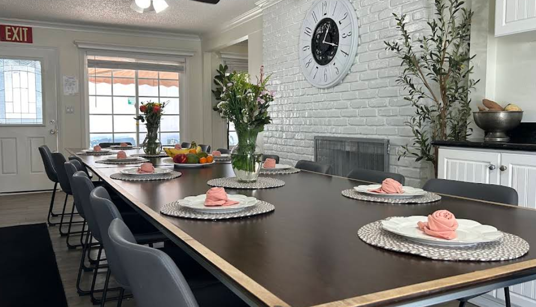 Long dining table with flowers and silver place settings