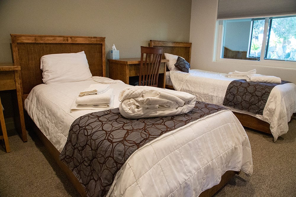 Shared bedroom with two twin beds and wooden furniture