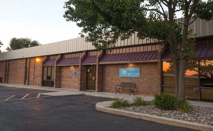 Rehab center entrance with bench and Mirror Inc. sign