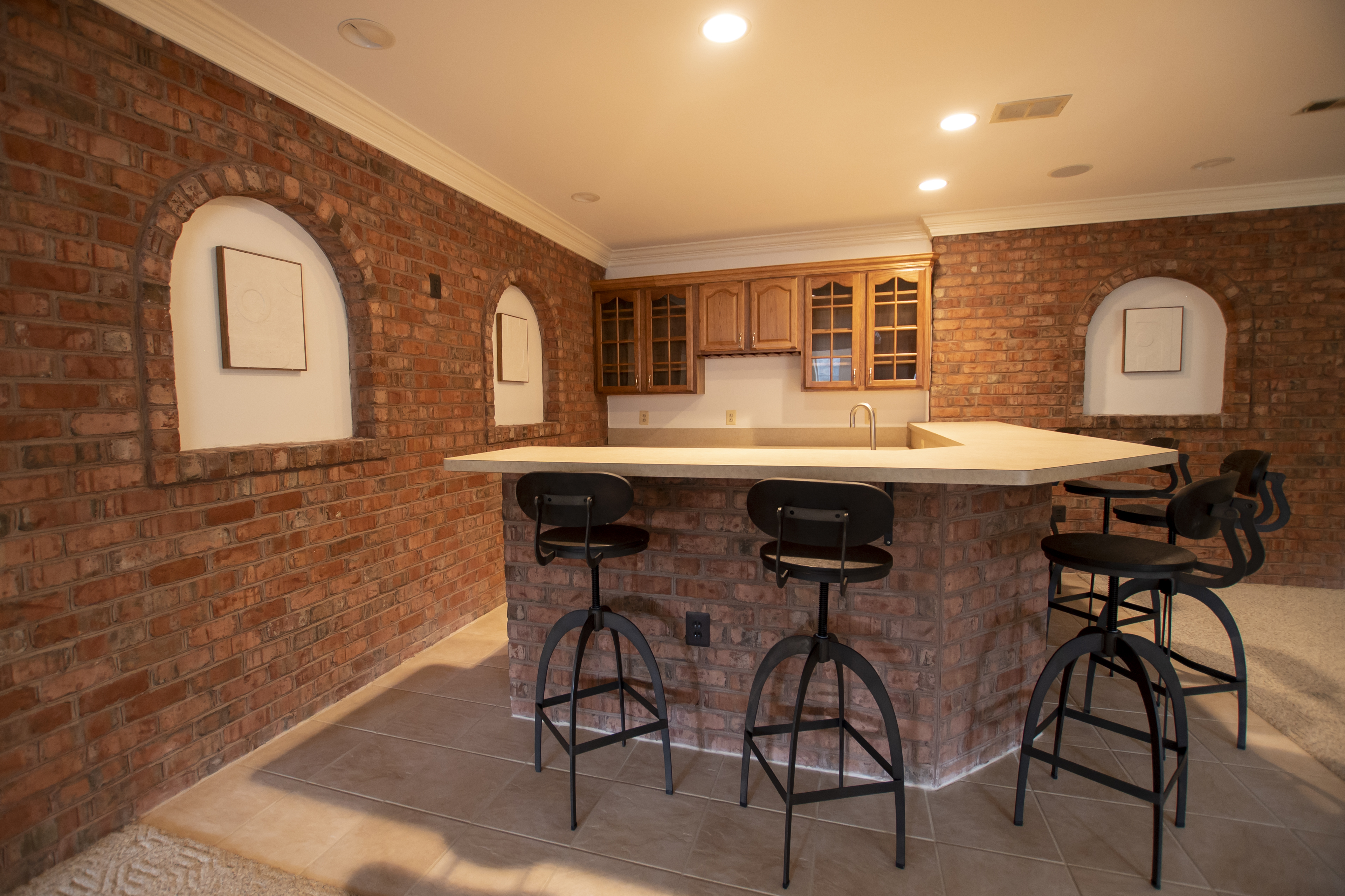 Brick bar area with counter and high stools.