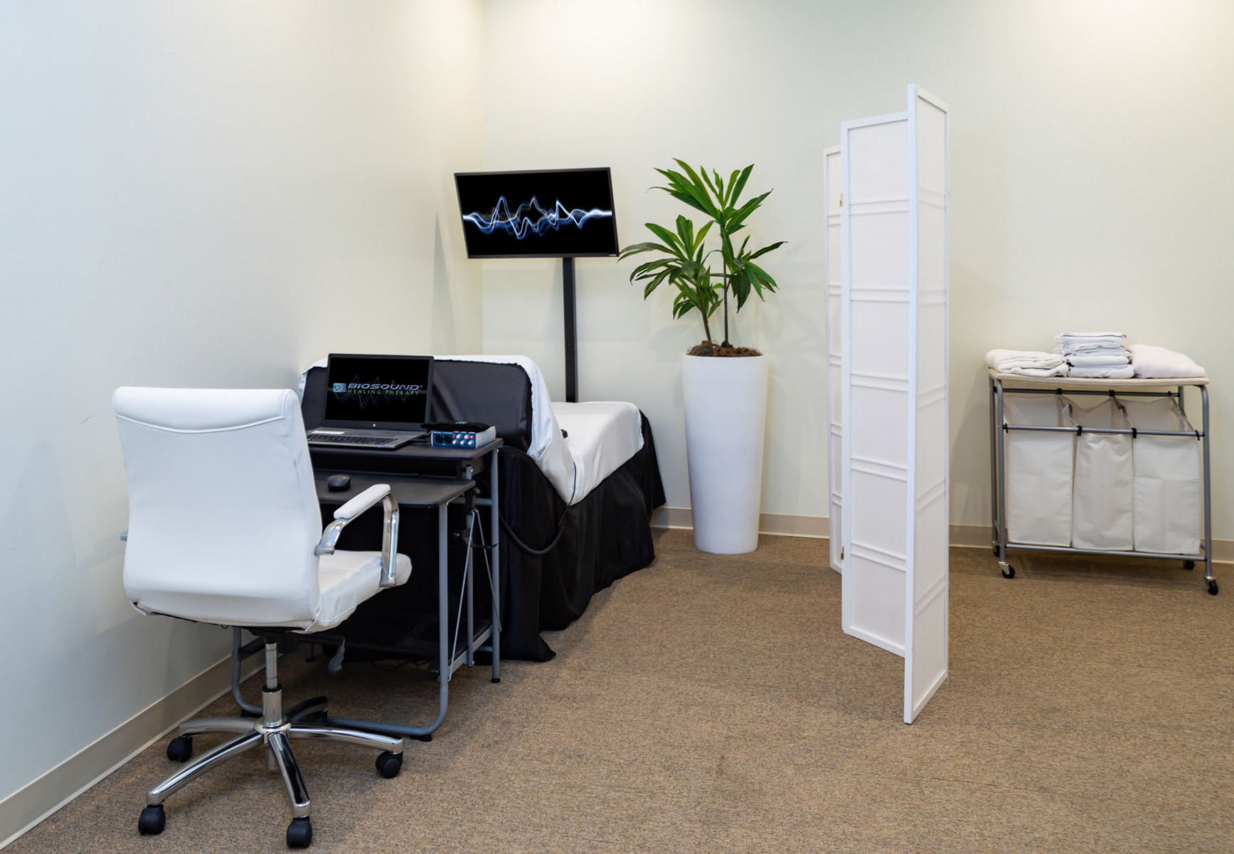 Room with therapy bed, chair, and monitor