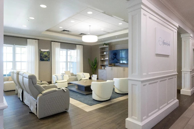 Bright lounge with armchairs and a TV.