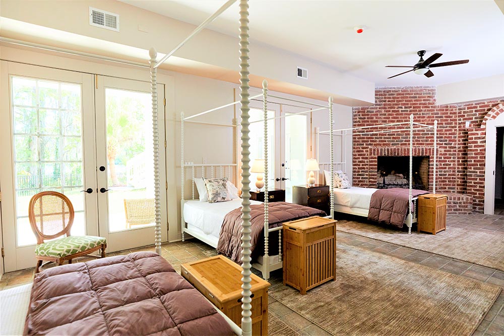 Shared bedroom with canopy beds and fireplace