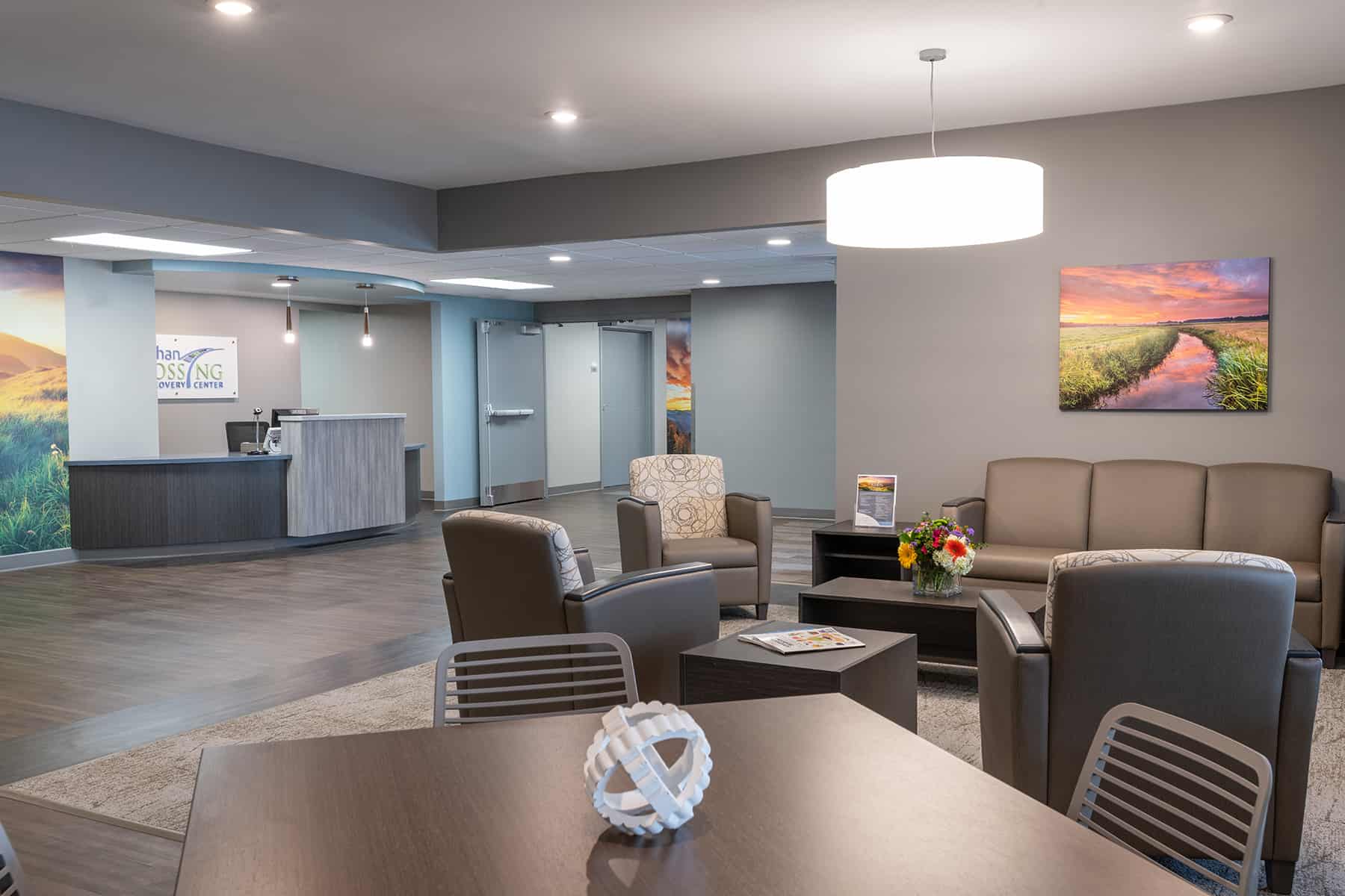 A spacious lobby with seating, a reception desk, and artwork.