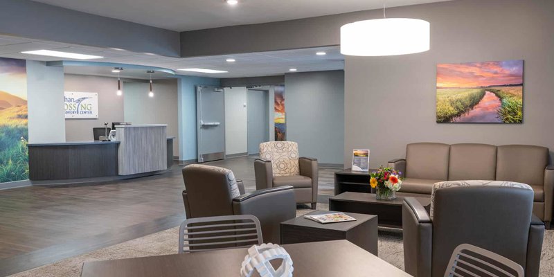 A warm, comfortable waiting area with modern furniture, soft lighting, nature-themed artwork, and a welcoming reception desk, offering a relaxing atmosphere.