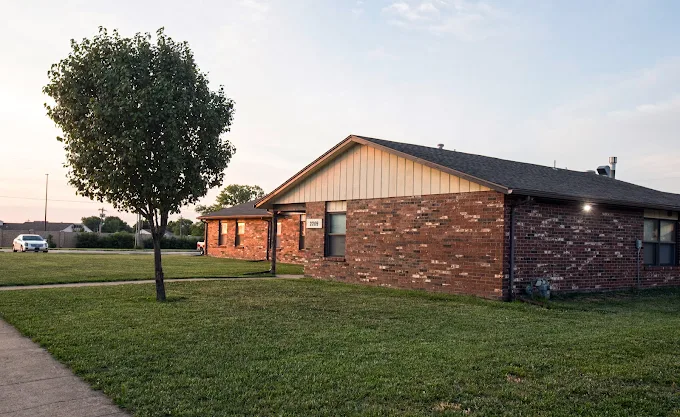 Brick rehab building with lawn and small tree
