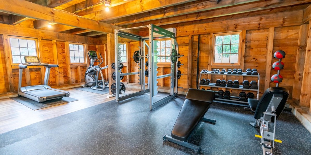 Wooden gym with treadmill, weights, and strength equipment