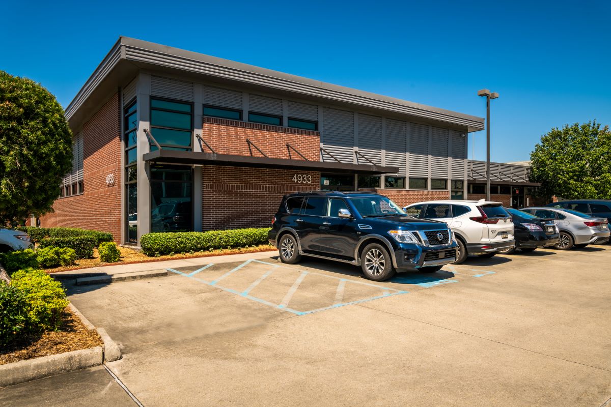 Modern brick rehab facility with parking lot and signage.