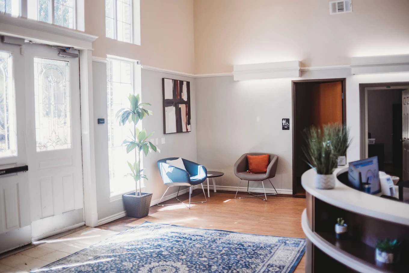 Reception area with front desk, seating, and tall windows