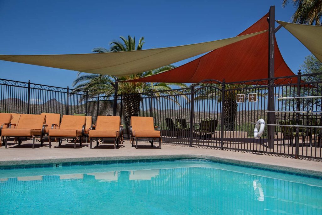 Outdoor pool with lounge chairs and shaded canopies