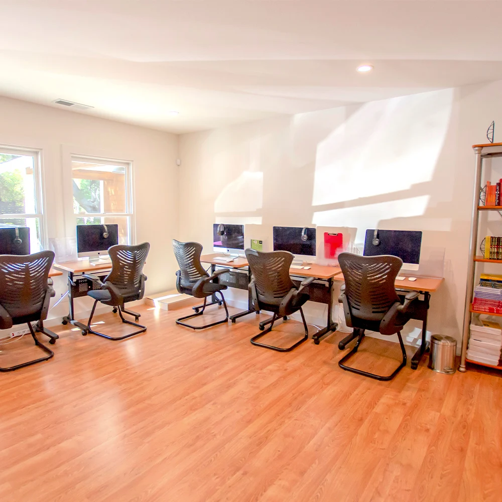 Computer room with desks, chairs, and iMacs