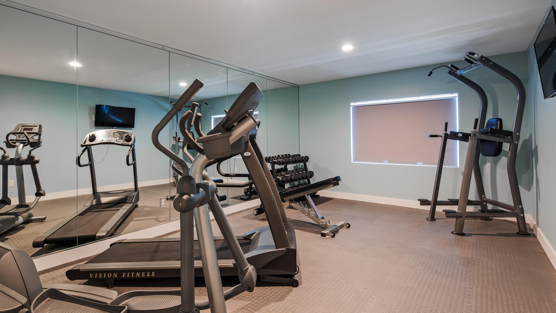 Gym with treadmills, weights, and exercise machines.