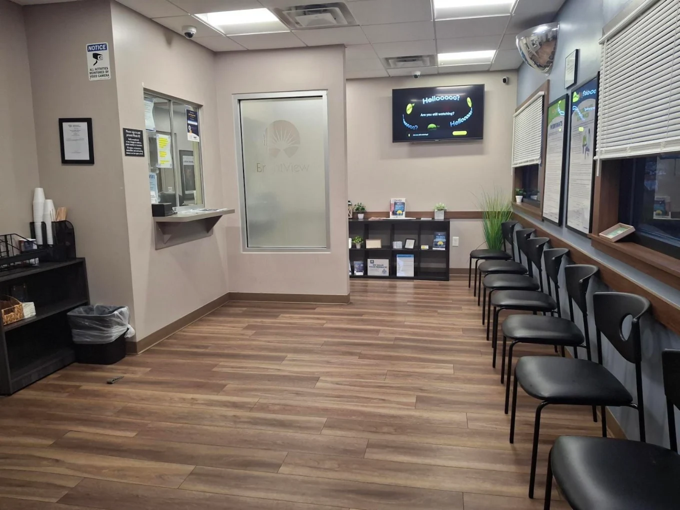 Waiting area with chairs, check-in window, and TV