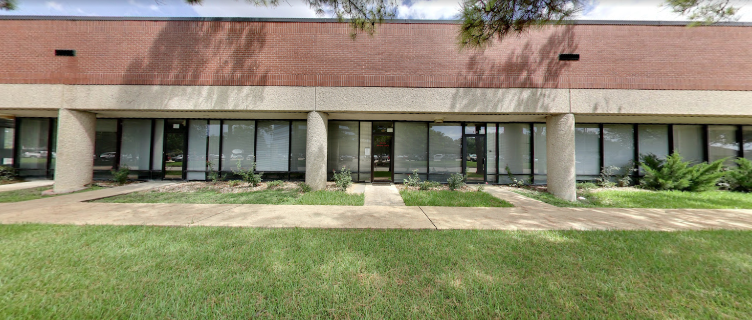 Brick and concrete building with walkway and windows