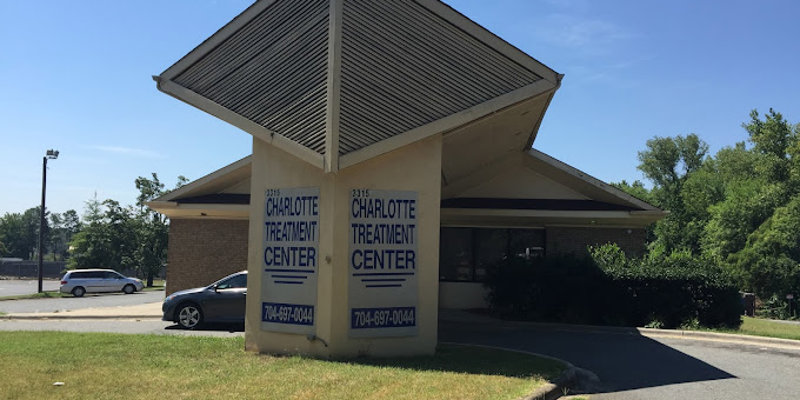 Charlotte Treatment Center's building exterior is shown with large signage displaying the center's name and contact information. The structure features a unique triangular roof design.