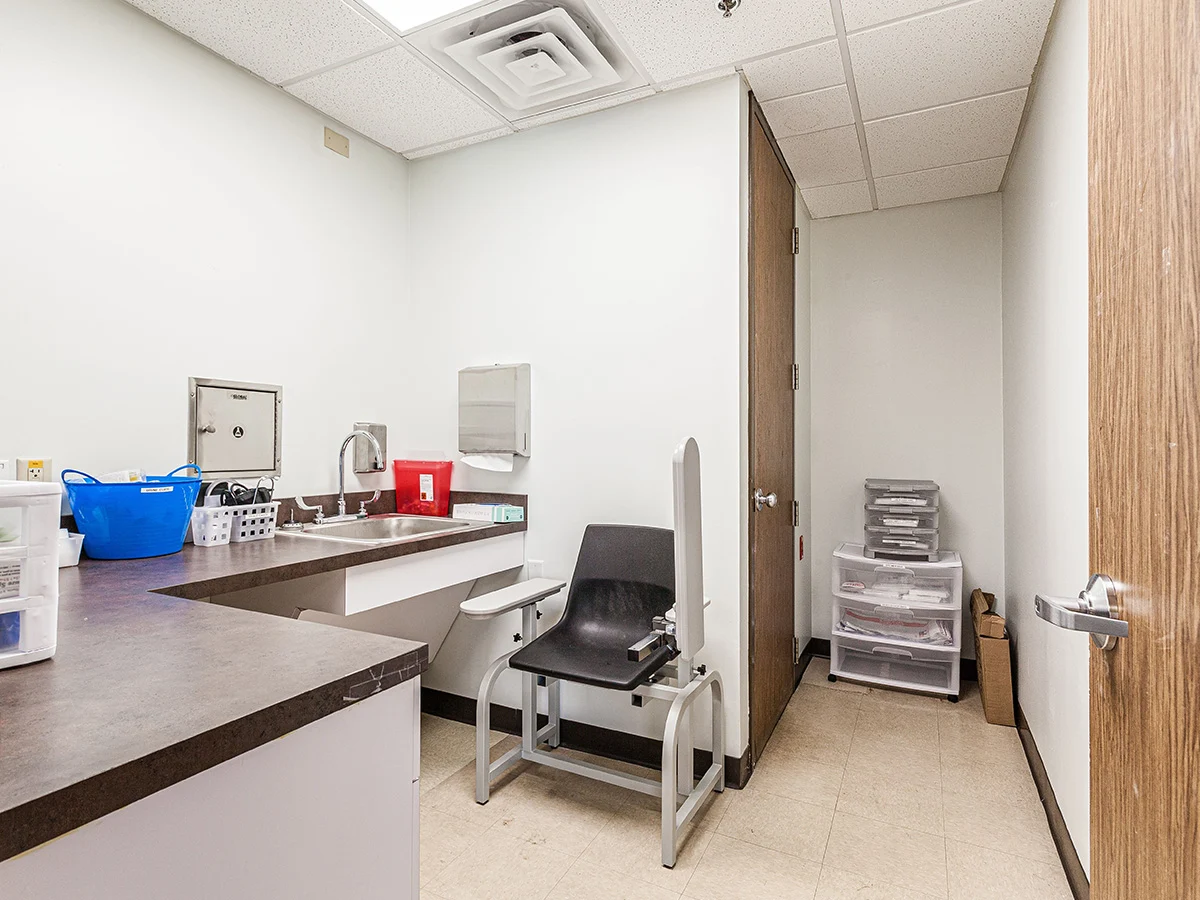 Clinical room with chair, sink, and storage bins