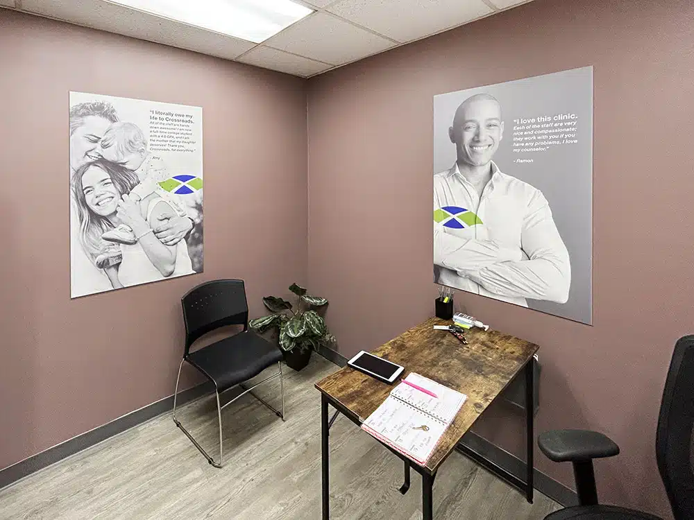 Small counseling room with desk, chair, and wall posters