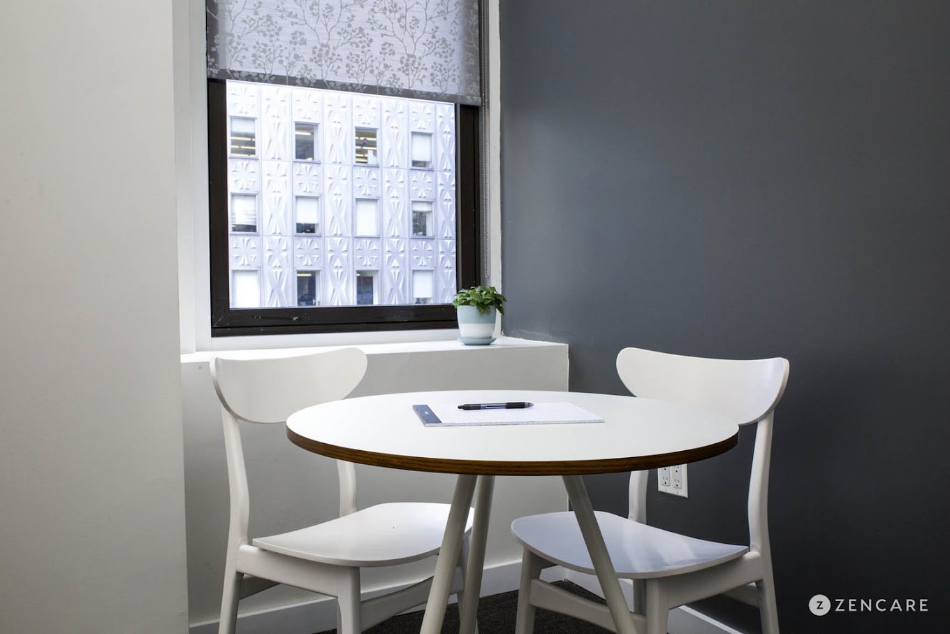 Small meeting area with white chairs.