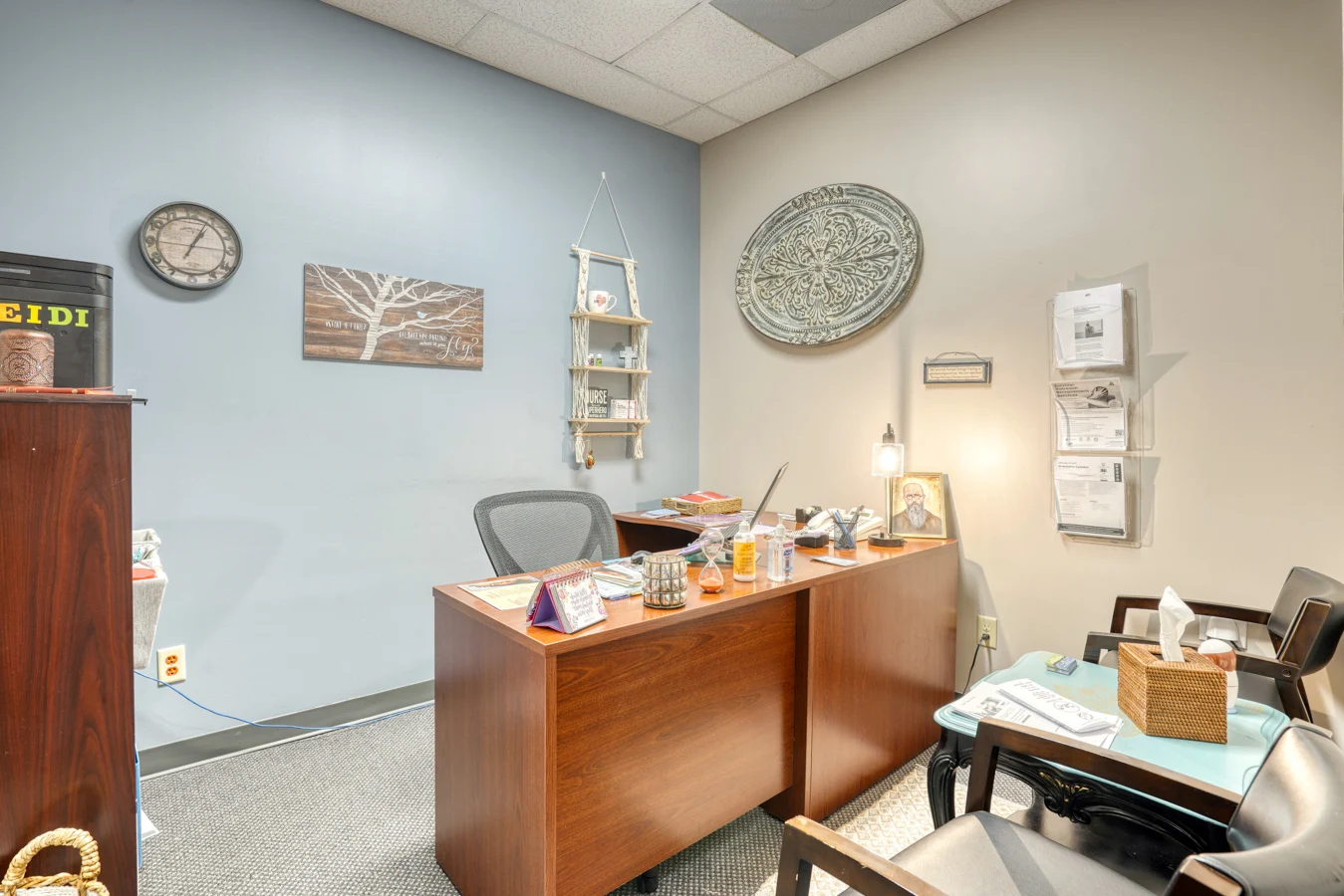 Private consultation room with desk, chairs, and wall decor