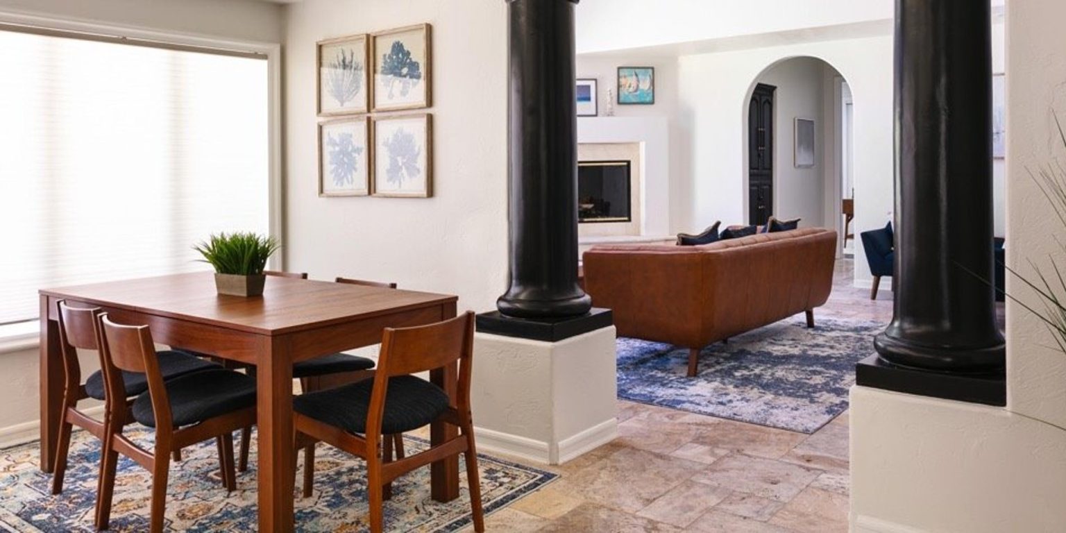 Dining area with wooden table, chairs, and open living space
