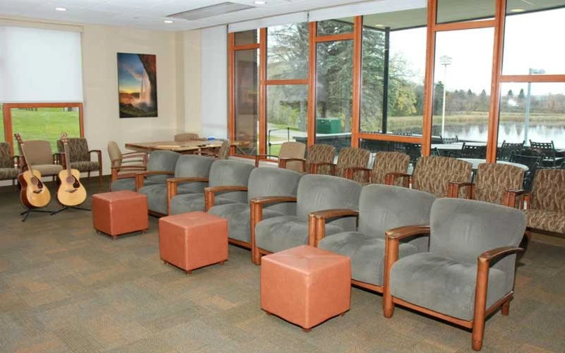 Circle of chairs in a sunny room with guitars by the window