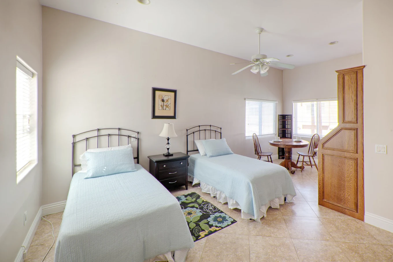 Twin beds in bright room with small dining nook